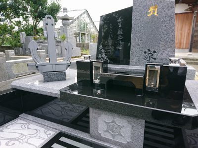 イカリのオブジェが飾られた庵治石と黒御影石の玉垣一体型現代墓