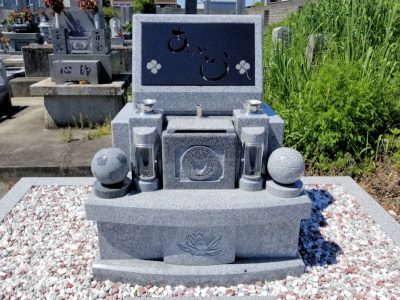 御影石のサッカーボールとバレーボールのオブジェがかざられた現代墓